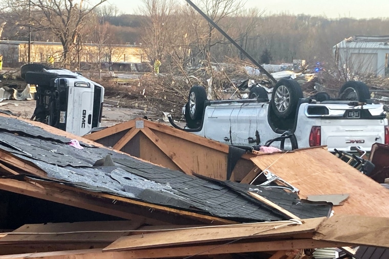 Up turned vehicles are seen next to damages structures after a tornado swept through Coralville, Iowa, Friday, March 31, 2023.