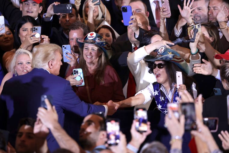 Former U.S. President Donald Trump (L) greets supporters during an event at Mar-a-Lago April 4, 2023 in West Palm Beach, Florida. Earlier in the day, Trump pleaded not guilty to 34 felony counts stemming from hush money payments in 2016 to two women, becoming the first  former U.S. president in history to be charged with a criminal offense.