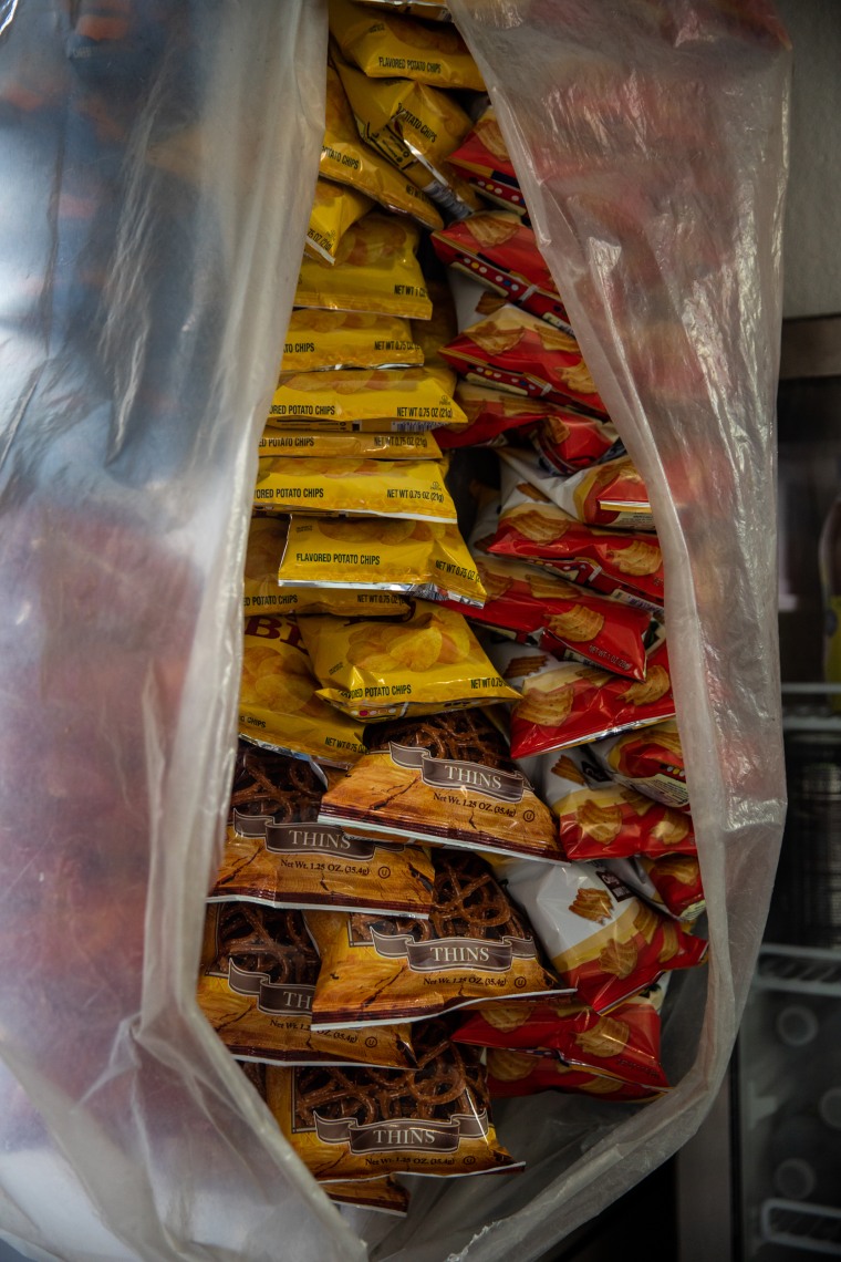 Bags of chips and pretzels are enclosed in a plastic bag near the fridge at Abul Kalam Azad's newsstand near New York Criminal Court on April 4, 2023.