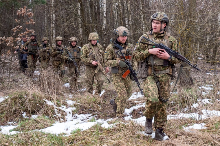 Ukrainian soldiers exit a forest after completing a drill at a forest north of Kyiv on March 31. 