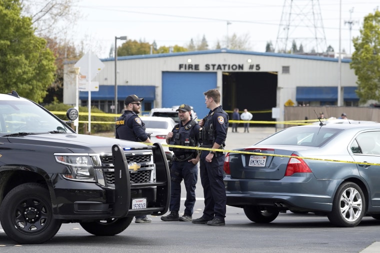 Roseville Police Officers stand at road block leading to the scene of a shooting that killed one person and wounded two others including a California Highway Patrol office, in Roseville, Calif., Thursday, April 6, 2023. California Highway Patrol officers were serving a warrant to the suspect when he began shooting. Two innocent bystanders were struck by the suspect's gunfire, killing one. The suspect surrendered and taken into custody.