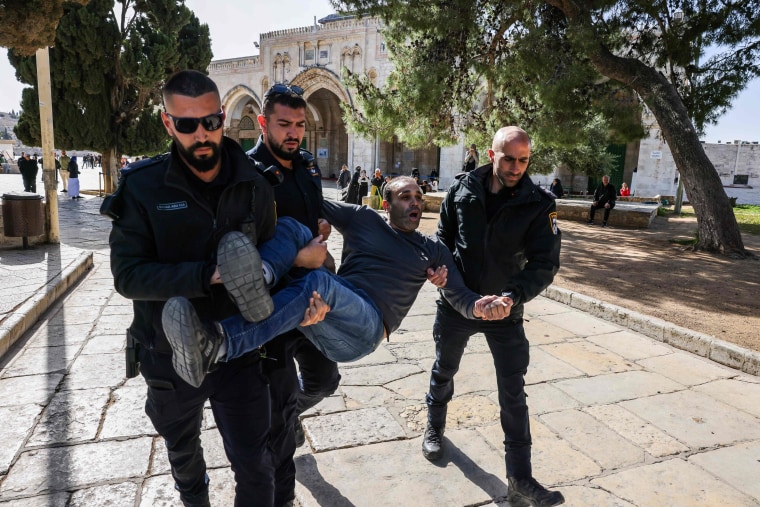 Israëlische politieagenten arresteren een Palestijnse man op het terrein van de Al-Aqsa Moskee na schermutselingen die uitbraken tijdens de islamitische vastenmaand Ramadan in Jeruzalem op 5 april 2023. -