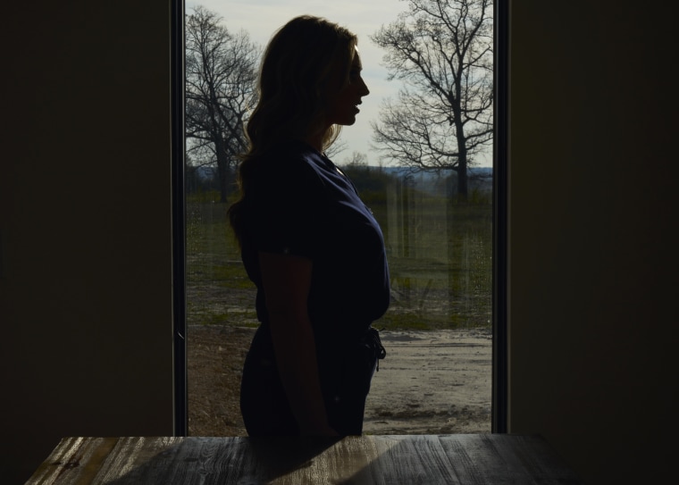 Image: Tiffany Dover in her nurse scrubs at home in Higdon, Ala., in March.