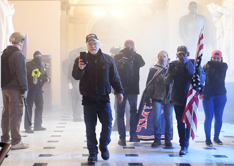 Supporters of President Donald Trump enter the Capitol as tear gas fills the corridor on Jan. 6, 2021. 