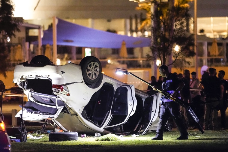 Image: Israeli police and emergency services work around a car involved in an attack in Tel Aviv on April 7, 2023.