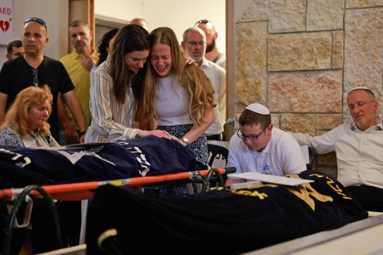 Relatives react during the funeral of two sisters killed in a shooting attack at the Kfar Etzion settlement in the occupied West Bank on April 9, 2023. 