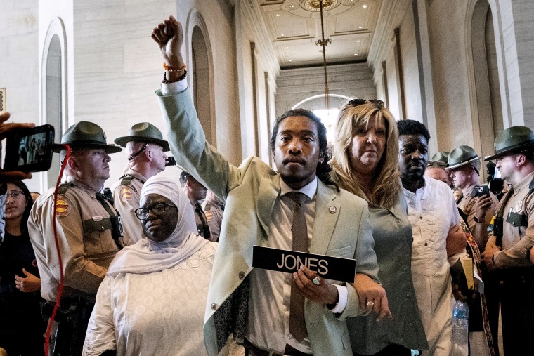 Metro Nashville Council member Zulfat Suara, left, and State Rep. Gloria Johnson escort State Rep. Justin Jones back to the House chamber on April 10, 2023, in Nashville.
