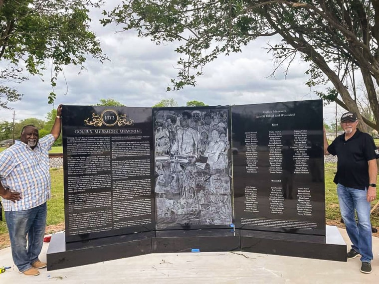 Avery Hamilton, left, and Charles Dean Woods stand next to the new monument honoring Black residents killed in the Colfax Massacre during 1873.