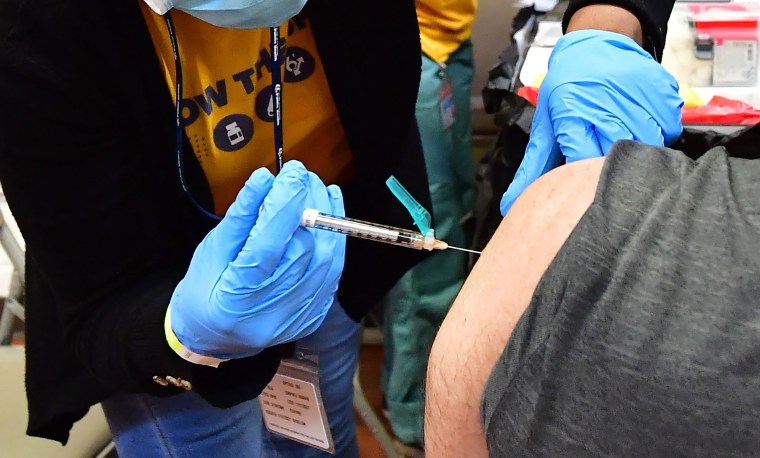 A person receives a Pfizer booster shot at a Covid vaccination and testing site in Los Angeles