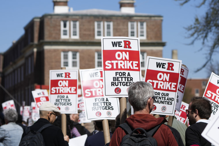 Rutgers strikers hold signs as they march on campus