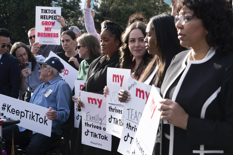 Supporters of TikTok hold signs during a rally to defend the app at the Capitol