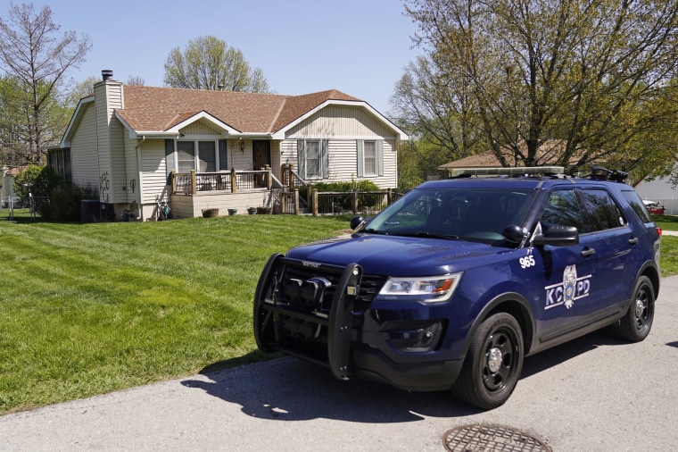 A police officer on April 17, 2023, walks past the house where 16-year-old Ralph Yarl was shot when he went to the wrong address to pick up his younger brothers in Kansas City, Mo.