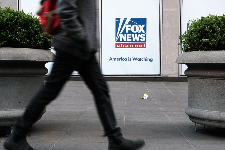 People walk by the News Corporation headquarters, home to Fox News, on April 18, 2023 in New York City. Moments before opening arguments were set to begin this afternoon, Fox News and Dominion Voting Systems said that they had reached a settlement of $787 million in the voting machine company's defamation lawsuit against Fox.
