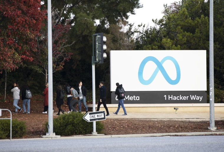 People walk past the Meta logo at its headquarters in Menlo Park, Calif.