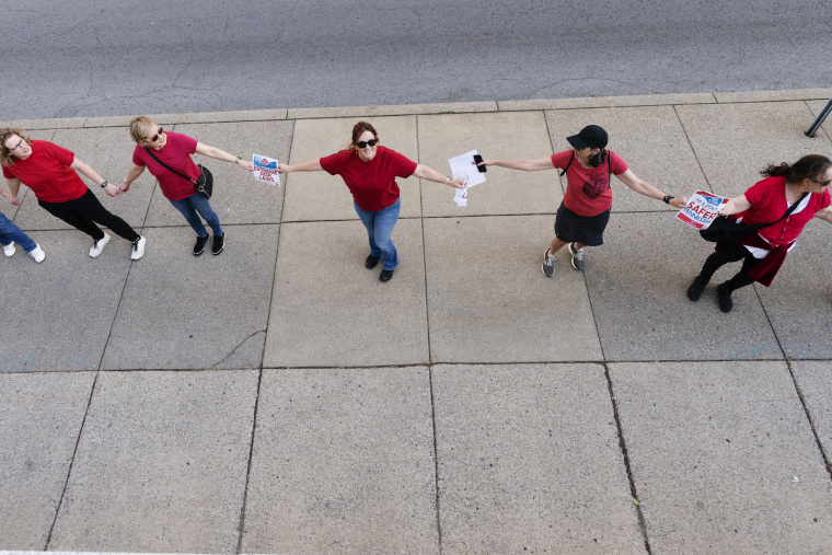 Demonstrators hold hands to form a "human chain" to support gun control legislation on April 18, 2023, in Nashville, Tenn. 