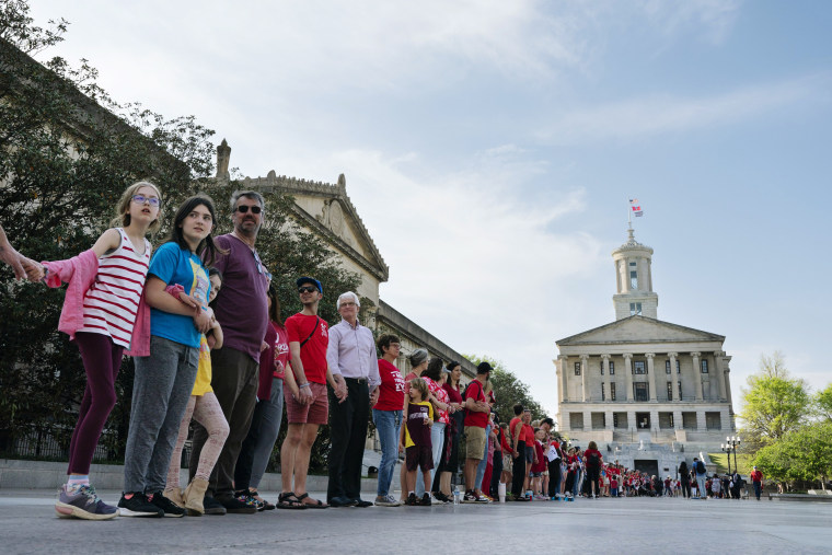 Demonstrators hold hands create a human chain to show support for gun control legislation on April 18, 2023, in Nashville, Tenn. The chain started at the hospital where victims of The Covenant School shooting were taken and ended at the Tennessee State Capitol. 