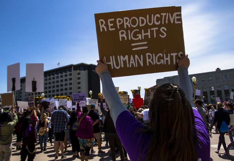 Activists hold abortion rights signs during a rally in Reno, Nev.