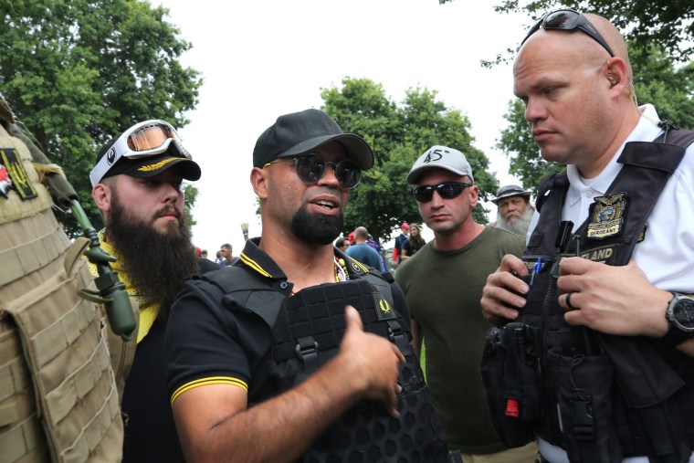 Proud Boys President Enrique Tarrio speaks with a police officer during a rally in Portland, Oregon.