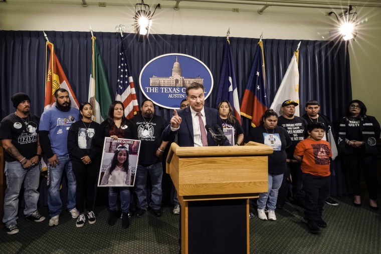 Image: Family of those killed by a gunman at Robb Elementary School in Uvalde stand with Texas State Sen. Roland Gutierrez, center, during a news conference at the Texas Capitol in Austin on Jan. 24, 2023.