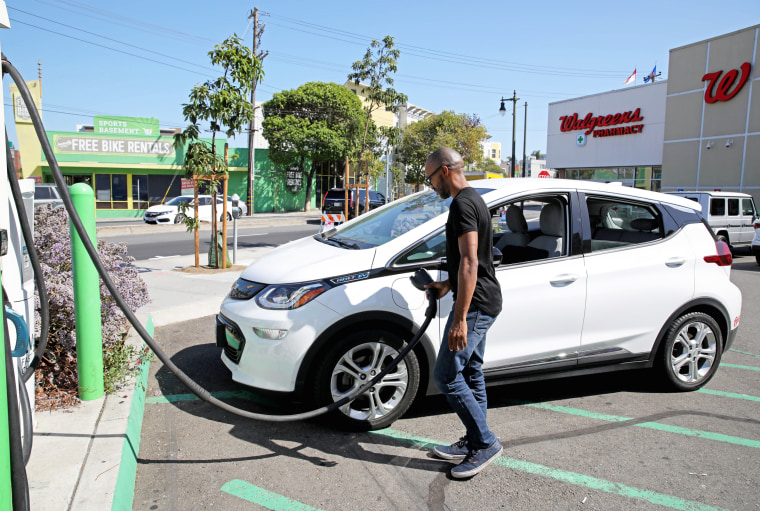 A man disconnects a Chevy Bolt from a charging station in San Francisco