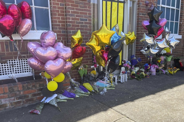 Flowers and balloons lay outside the Mahogany Masterpiece dance studio in Dadeville, Ala.