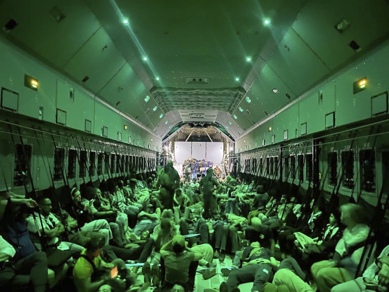 Different nationalities fleeing from Sudan, sit inside a Spanish Air Force aircraft on its way to Madrid