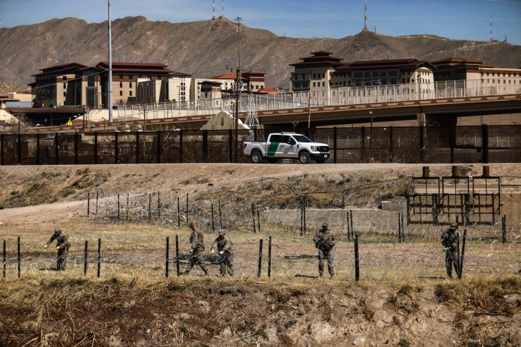 National Guard agents place a barbed wire wall on the banks of the Rio Grande in El Paso, Texas, on the border with Ciudad Juarez, Chihuahua State, Mexico, on March 8, 2023.