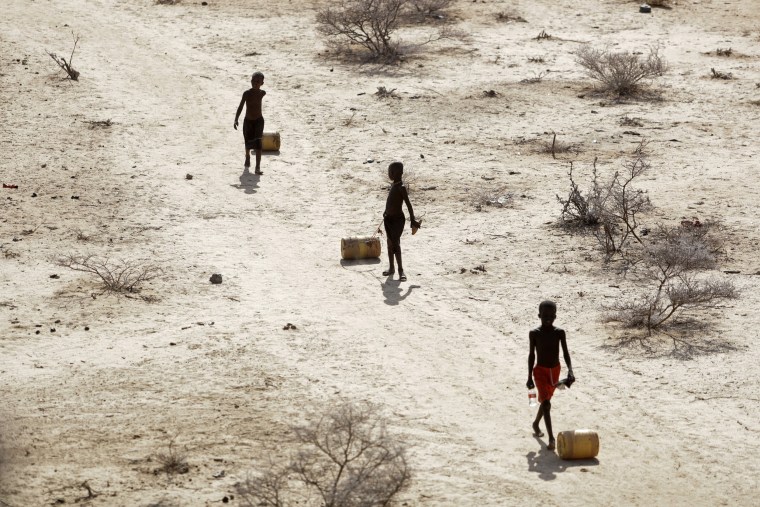 Young boys pull containers of water as they return from a well in the village of Ntabasi in Kenya, on Oct, 14, 2022. 