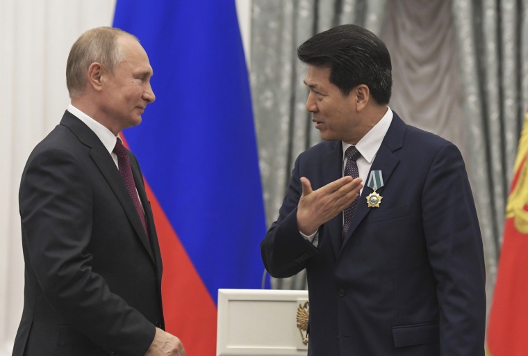 Russian President Vladimir Putin presents a state award to Li Hui at the Kremlin