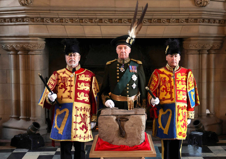 The Duke of Buccleuch Richard Scott, center, flanked by two Officers of Arms, stands by the Stone of Destiny during a special ceremony at Edinburgh Castle