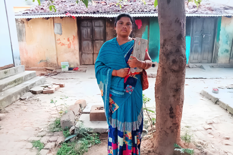 Sharada standing outside her house in Jurakhaman, Kalahandi in Odisha