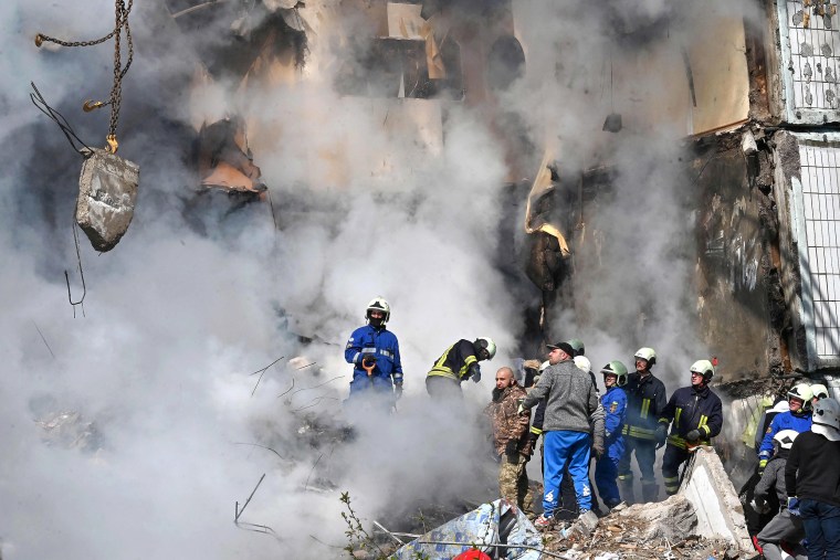 Rescuers search for survivors in the rubble of a damaged residential building in Uman, around 215km south of Kyiv, on April 28, 2023, after Russian missile strikes targeted several Ukrainian cities overnight. - Ukraine and Russia have been fighting since Moscow's February 2022 invasion and Ukraine says it has been preparing for months a counter-offensive aimed at repelling Russian forces from the territory they currently hold in the east and south.