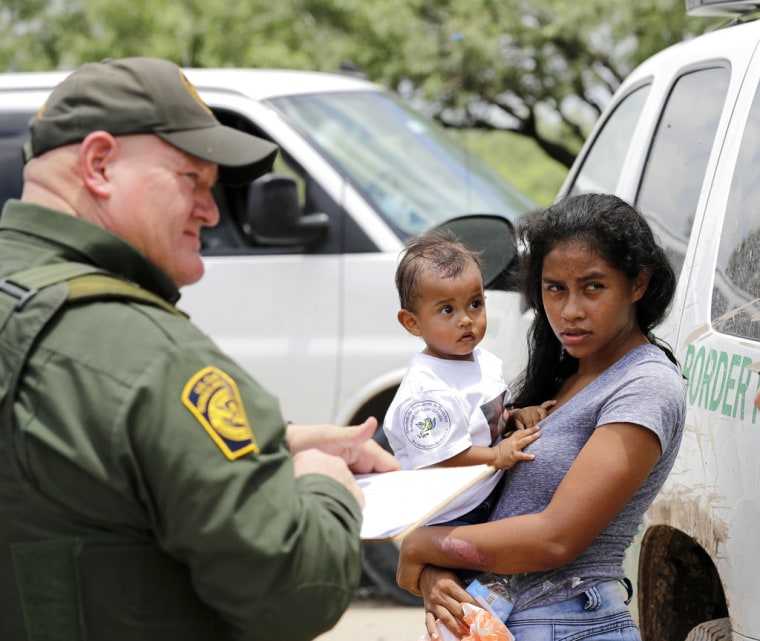 Una madre hondureña y su hijo de 1 año se entregan a un miembro de la Patrulla Fronteriza cerca de McAllen, Texas, en junio de 2018.
