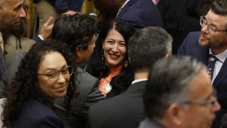 Un grupo de personas latinas e saluda entre sí. Al centro está la poetisa Ada Limón, sonriente. Es un evento en la Casa Blanca por el Mes de la Herencia Hispana en septiembre de 2022.