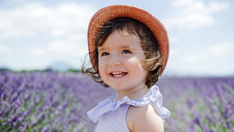 Happy toddler girl in purple lavender fields in the summer