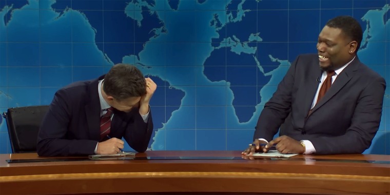 Colin Jost keeling over in laughter after being pranked by Michael Che.