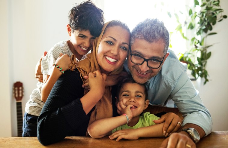 Portrait of happy family sitting at table