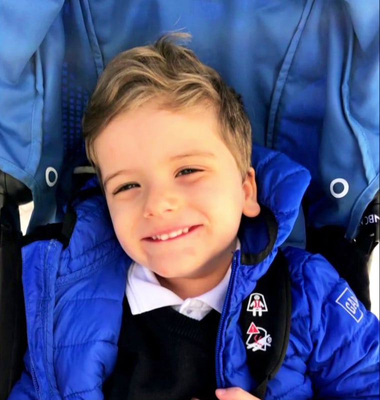 Henry smiles wearing a blue puffer jacket.