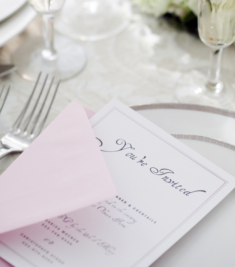 Wedding invitation on table setting.
