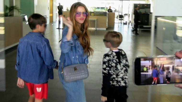 Shakira con sus hijos Milan y Sasha en el aeropuerto, seguidos por paparazzi.