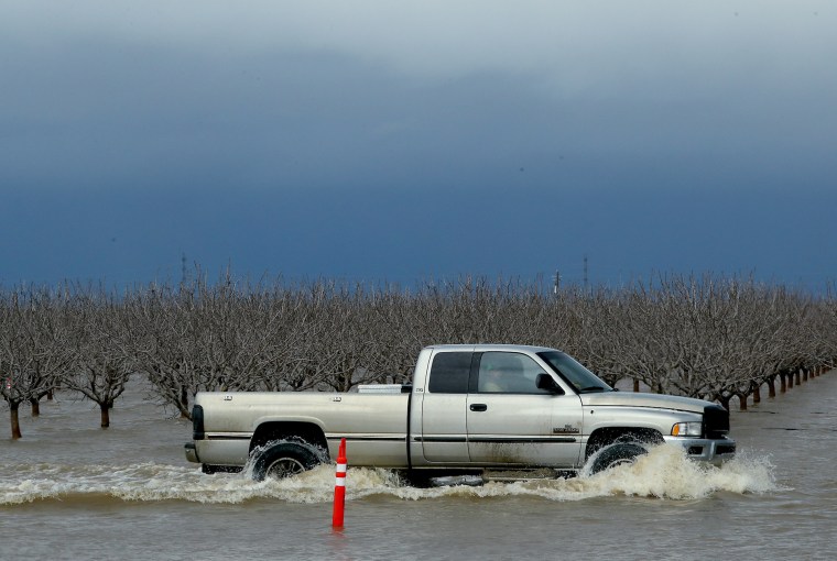 Una camioneta avanza a través de una arboleda de pistacho inundada cerca de Corcoran, en el Valle de San Joaquín, California.