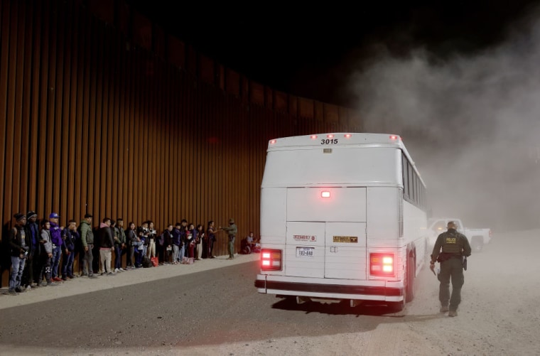 Un grupo de migrantes se disponen a abordar un autobús de las autoridades estadounidenses para ser procesados tras la expiración del Título 42 el 11 de mayo de 2023 en Yuma, Arizona.