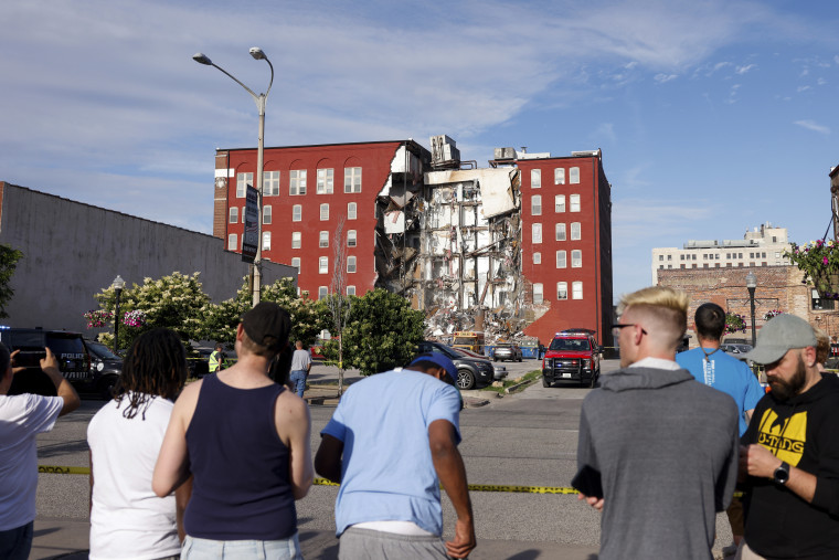 Los espectadores observan cómo los equipos de emergencia trabajan en la escena del derrumbe parcial de un edificio el domingo en Main Street en Davenport, Iowa.