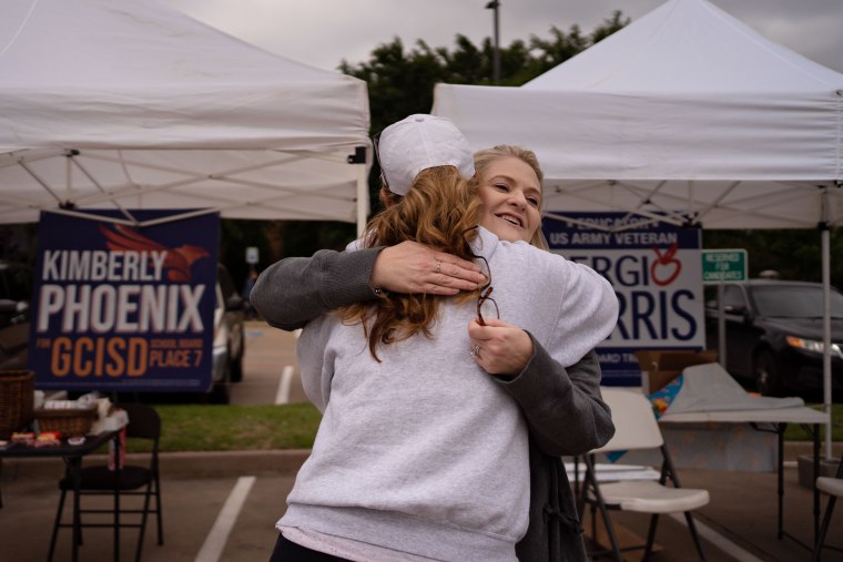 Image: Kimberly Phoenix hugs an acquaintance outside a voting location at Grapevine Library in Texas.
