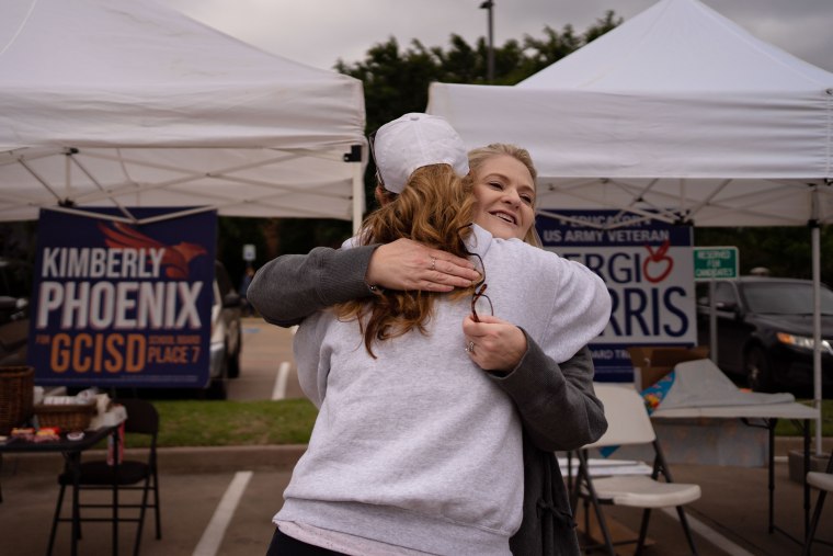 Image: Kimberly Phoenix hugs an acquaintance outside a voting location at Grapevine Library in Texas. 