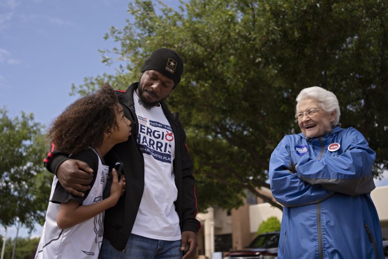 Image: Sergio Harris hugs his son while speaking to supporters.