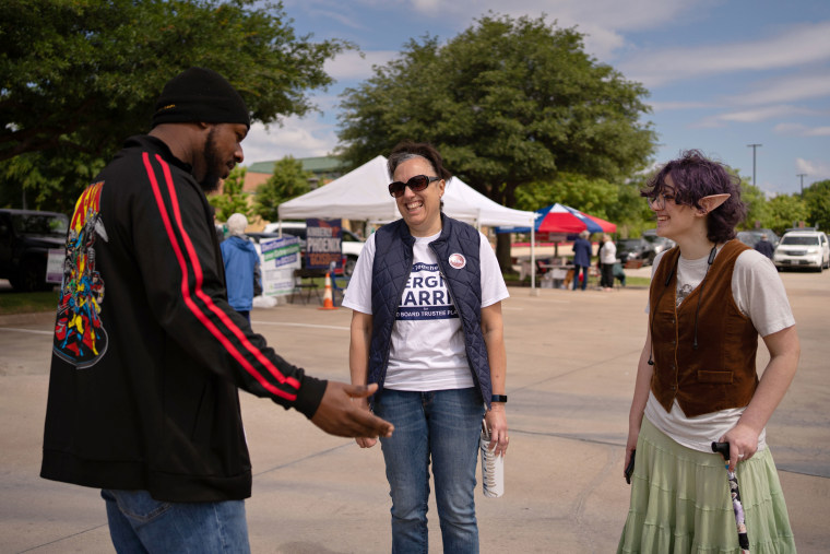 Image: Teddy and their mom, center, speak with GCISD school board candidate Sergio Harris on Saturday.