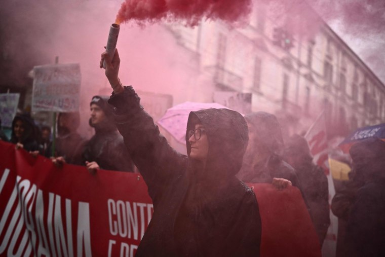 Un manifestante enciende una bengala durante una manifestación el Primero de Mayo en Turín, Italia.