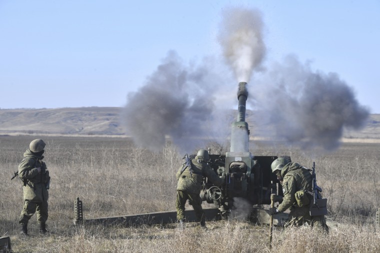 Russian servicemen fire a 2A18 D-30 howitzer toward Ukrainian positions