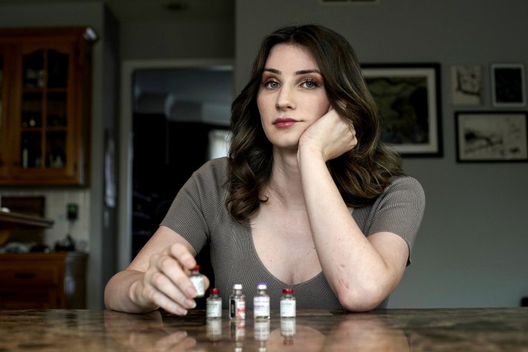 Stacy Cay displays some of the hormone therapy drugs she has stockpiled in fear of losing her supply on April 20, 2023, at her home in Overland Park, Kan.